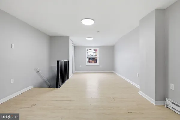 a view of an empty room with a window and fireplace