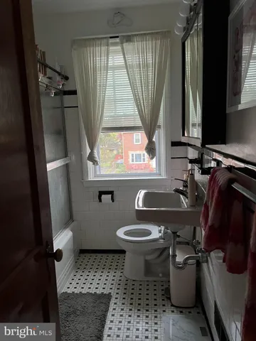 a bathroom with a toilet a sink and a window