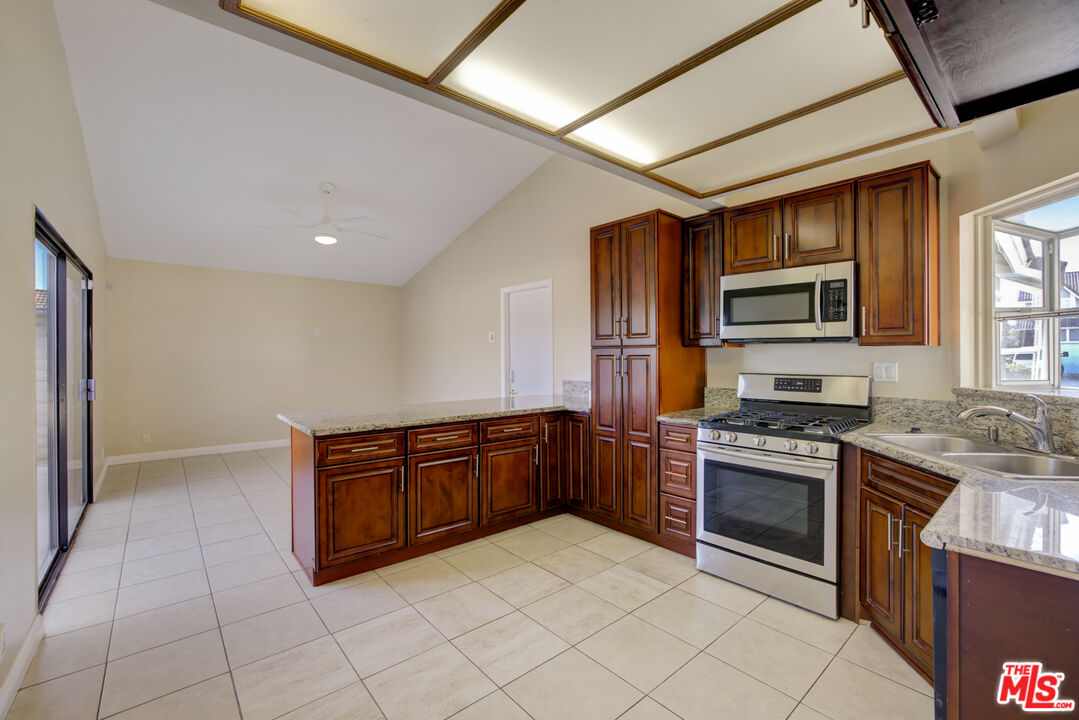 214 South Raspberry Lane Anaheim, CA 92808 - Photo 17 of 35 a kitchen with stainless steel appliances granite countertop a stove a sink and a refrigerator