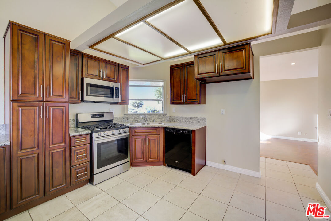214 South Raspberry Lane Anaheim, CA 92808 - Photo 4 of 35 a kitchen with stainless steel appliances granite countertop a refrigerator and a stove top oven