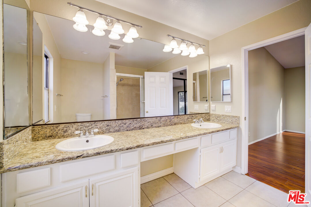 214 South Raspberry Lane Anaheim, CA 92808 - Photo 6 of 35 a bathroom with a granite countertop double vanity sink and a mirror