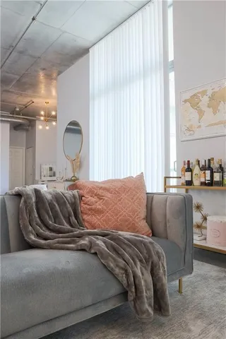 a living room with a couch and a large window with mirror