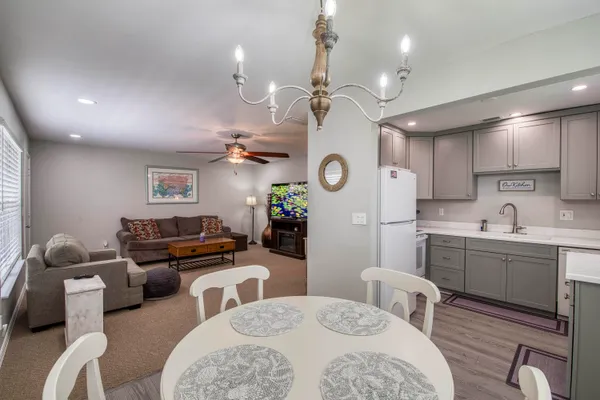 a living room with furniture kitchen view and a chandelier