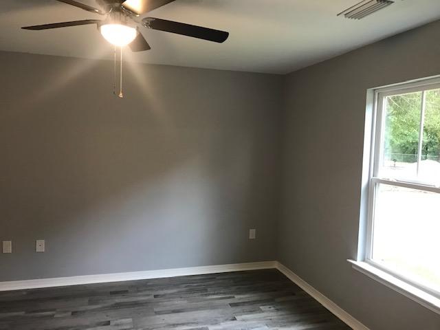 3328 Broadview Circle Crestview, FL 32539 - Photo 28 of 40 en empty room with wooden floor and windows