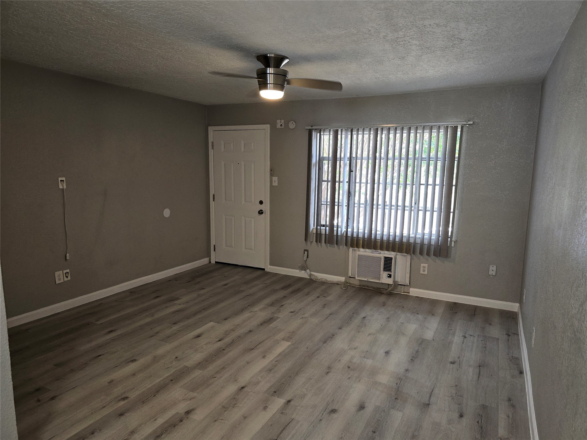 2501 Yoakum Boulevard, Unit 13 Houston, TX 77006 - Photo 15 of 24 an empty room with wooden floor and windows