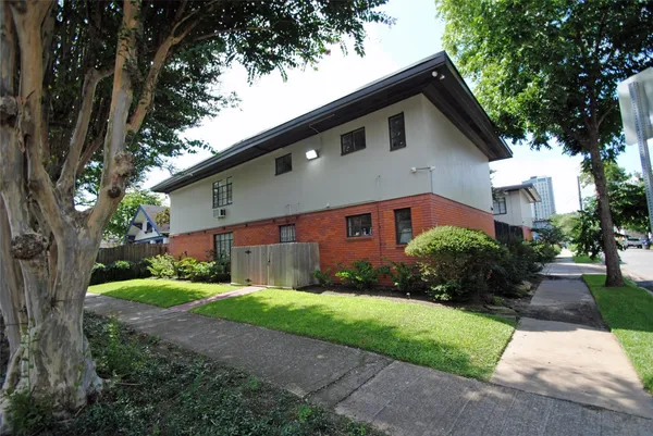 a front view of a house with a yard and trees