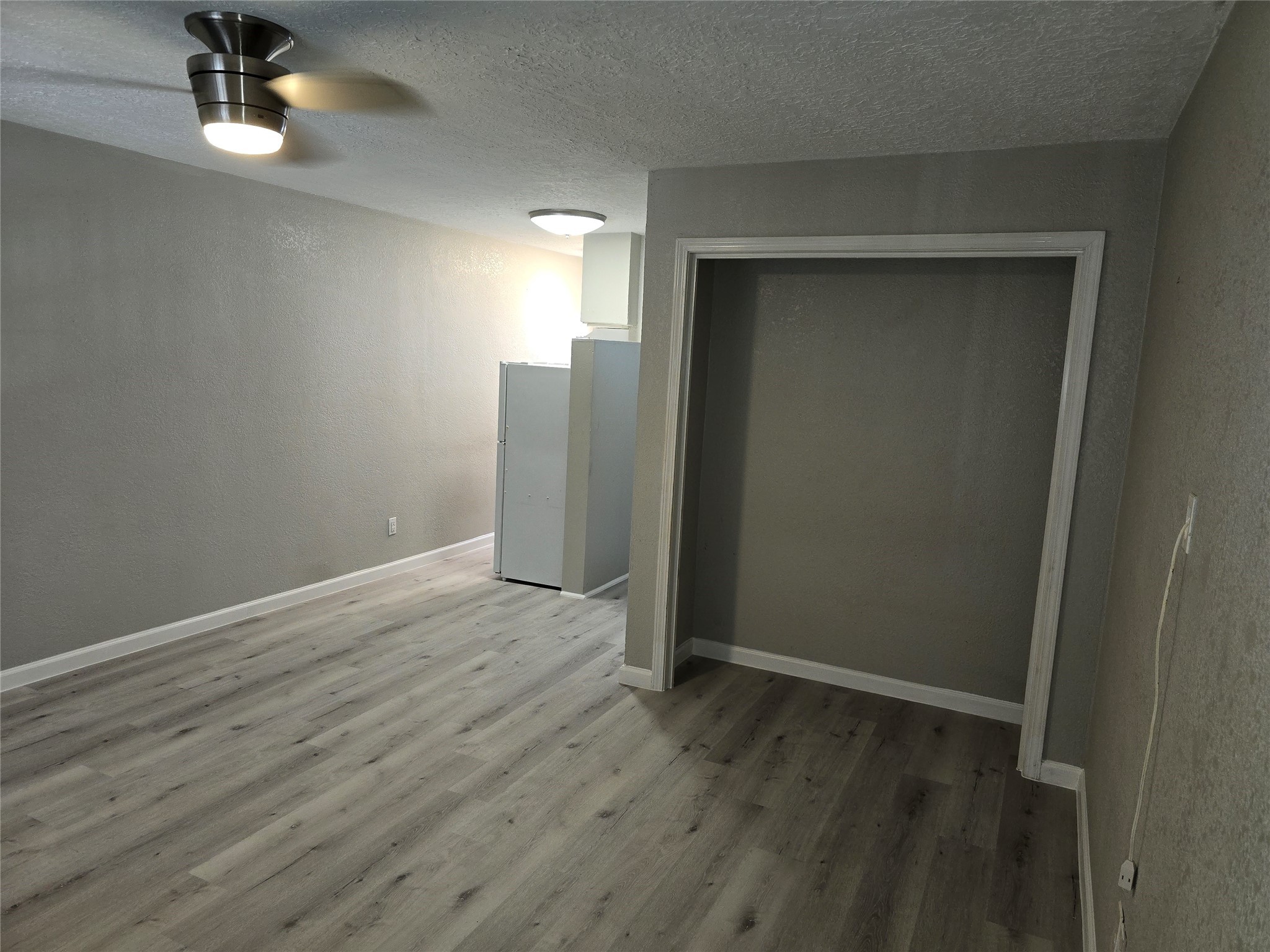 2501 Yoakum Boulevard, Unit 13 Houston, TX 77006 - Photo 4 of 24 an empty room with wooden floor cabinet and windows