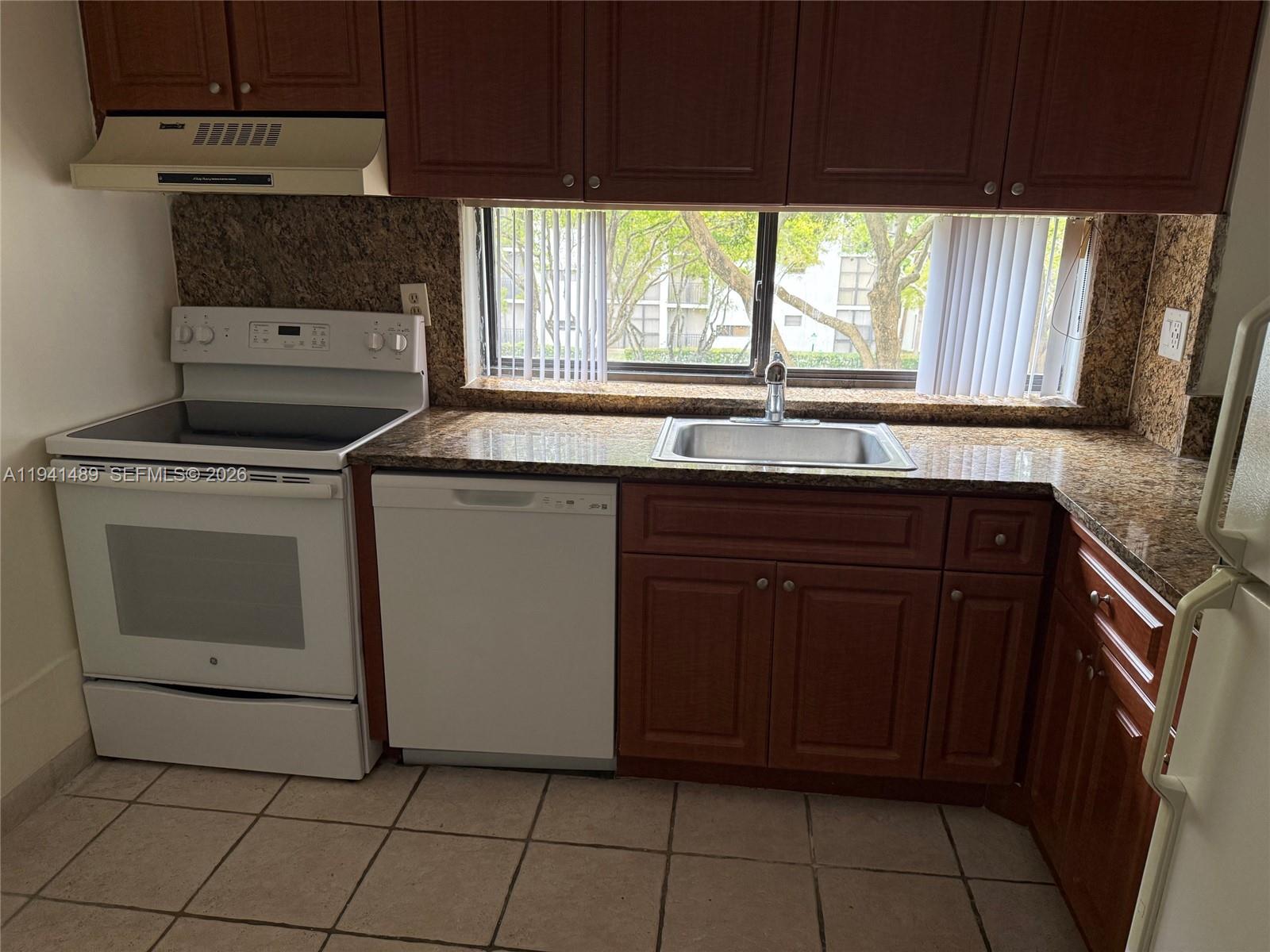 16919 North Bay Road, Unit 314 Sunny Isles Beach, FL 33160 - Photo 23 of 34 a kitchen with a stove sink and cabinets