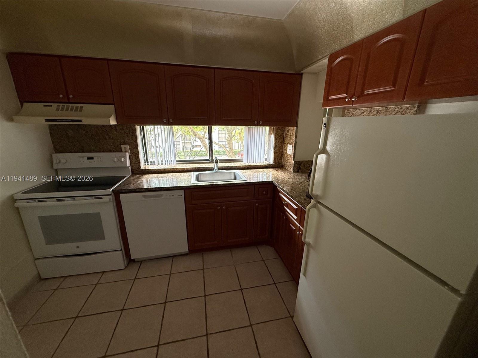 16919 North Bay Road, Unit 314 Sunny Isles Beach, FL 33160 - Photo 24 of 34 a kitchen with a sink a stove top oven and cabinets