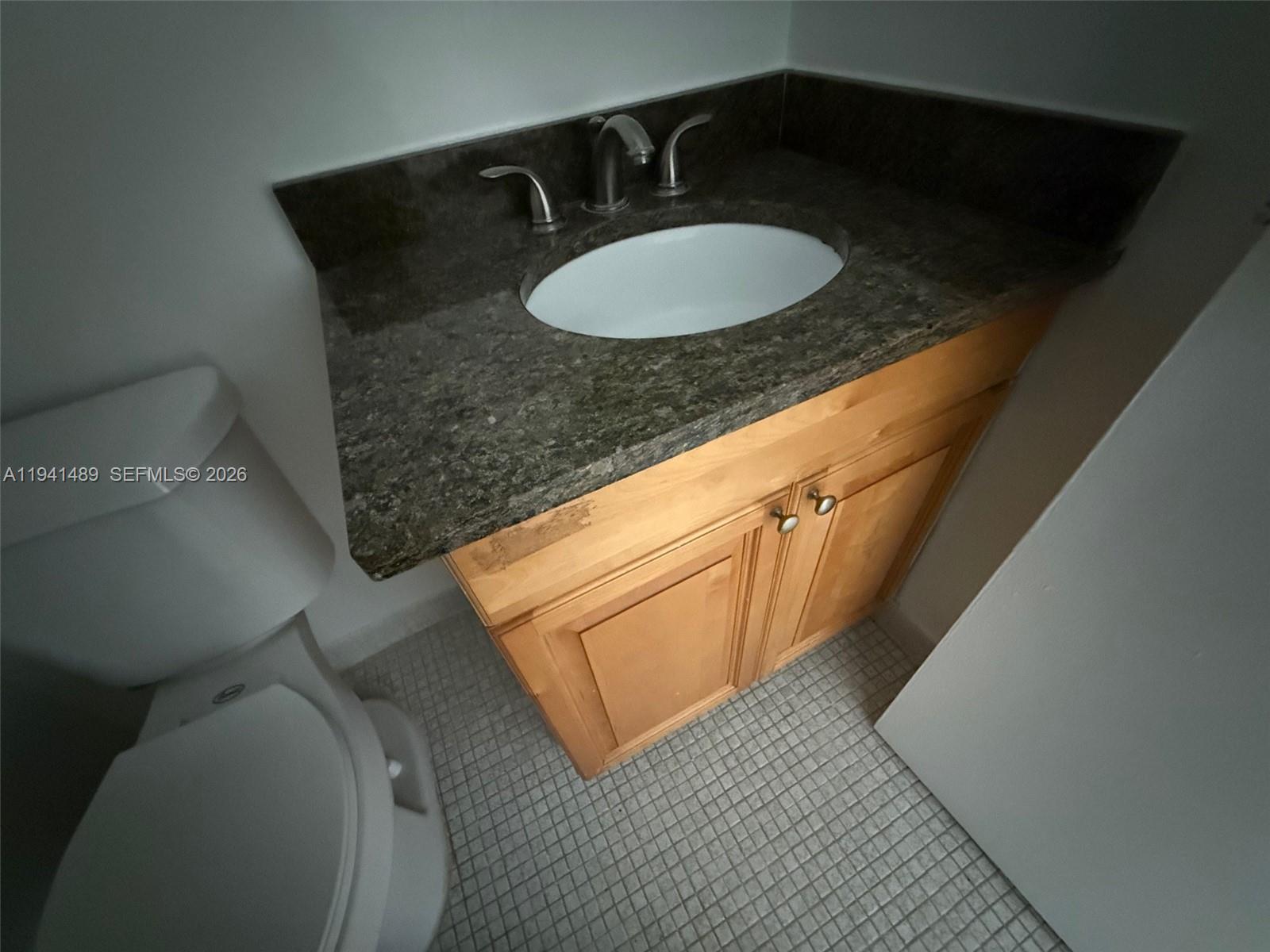 16919 North Bay Road, Unit 314 Sunny Isles Beach, FL 33160 - Photo 26 of 34 a bathroom with a granite countertop sink and a mirror