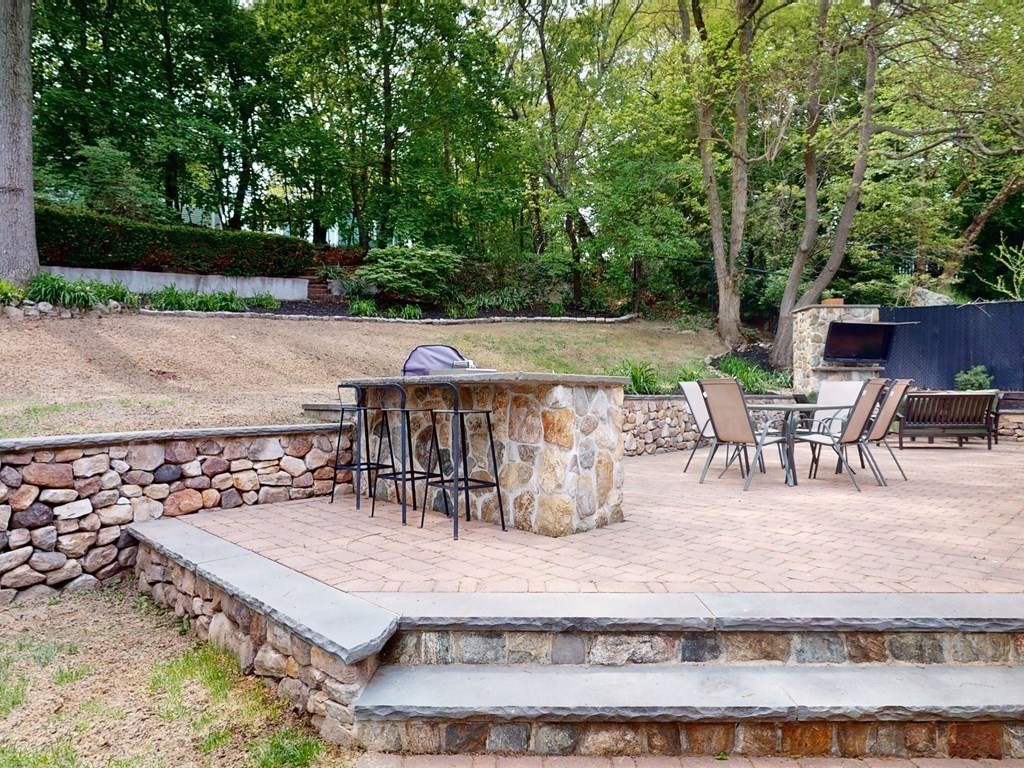 30 Baker Road Arlington, MA 02474 - Photo 32 of 42 a view of a patio with table and chairs potted plants and large tree