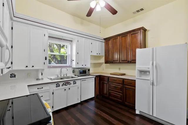 a kitchen with a sink a center island cabinets and stainless steel appliances