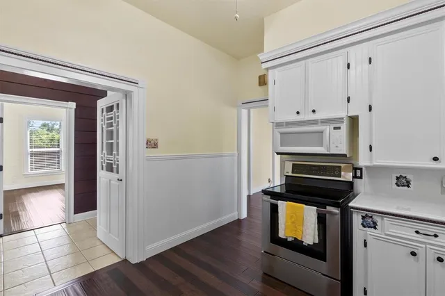 a kitchen with granite countertop white cabinets and appliances
