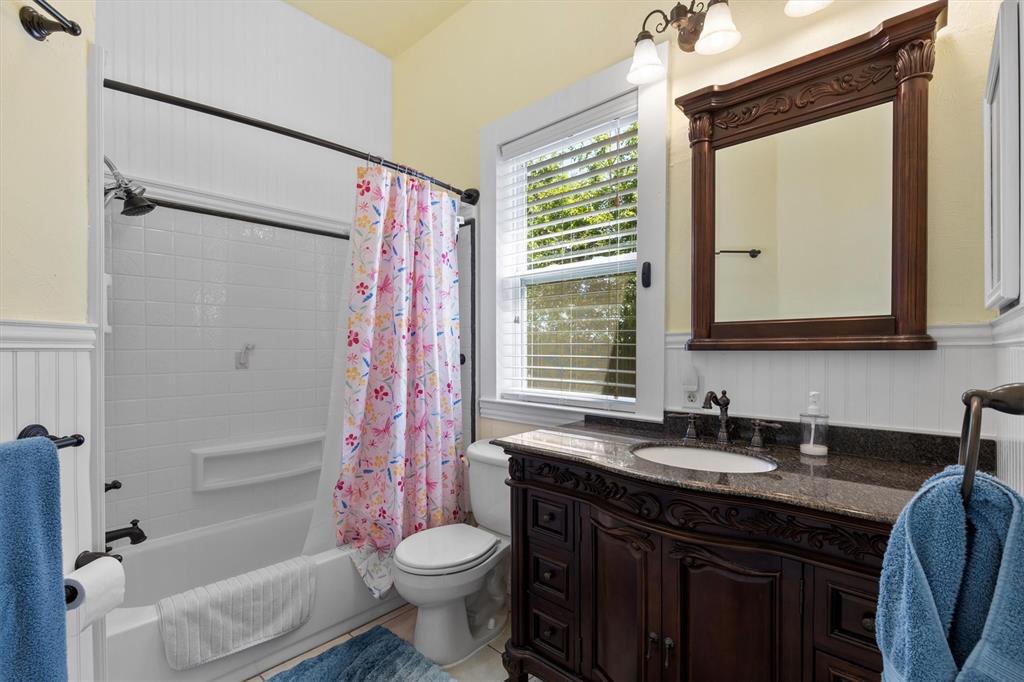 5824 Boone Street Sachse, TX 75048 - Photo 25 of 37 a bathroom with a sink a toilet a mirror and shower