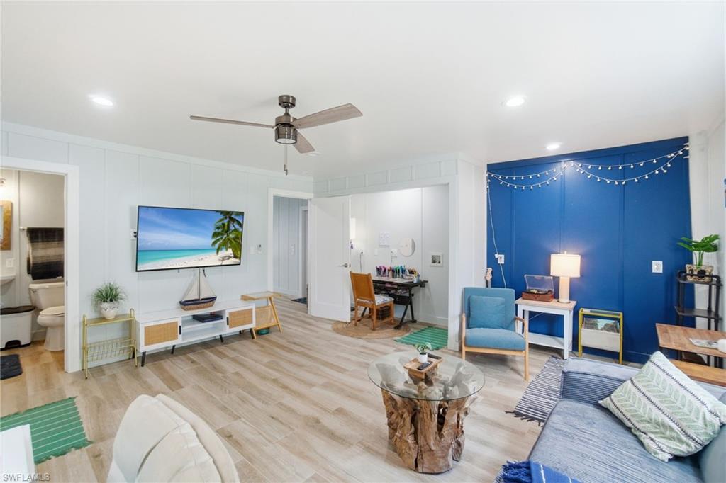 1286 Venetian Way Naples, FL 34110 - Photo 26 of 46 a living room with furniture a wooden floor and a flat screen tv