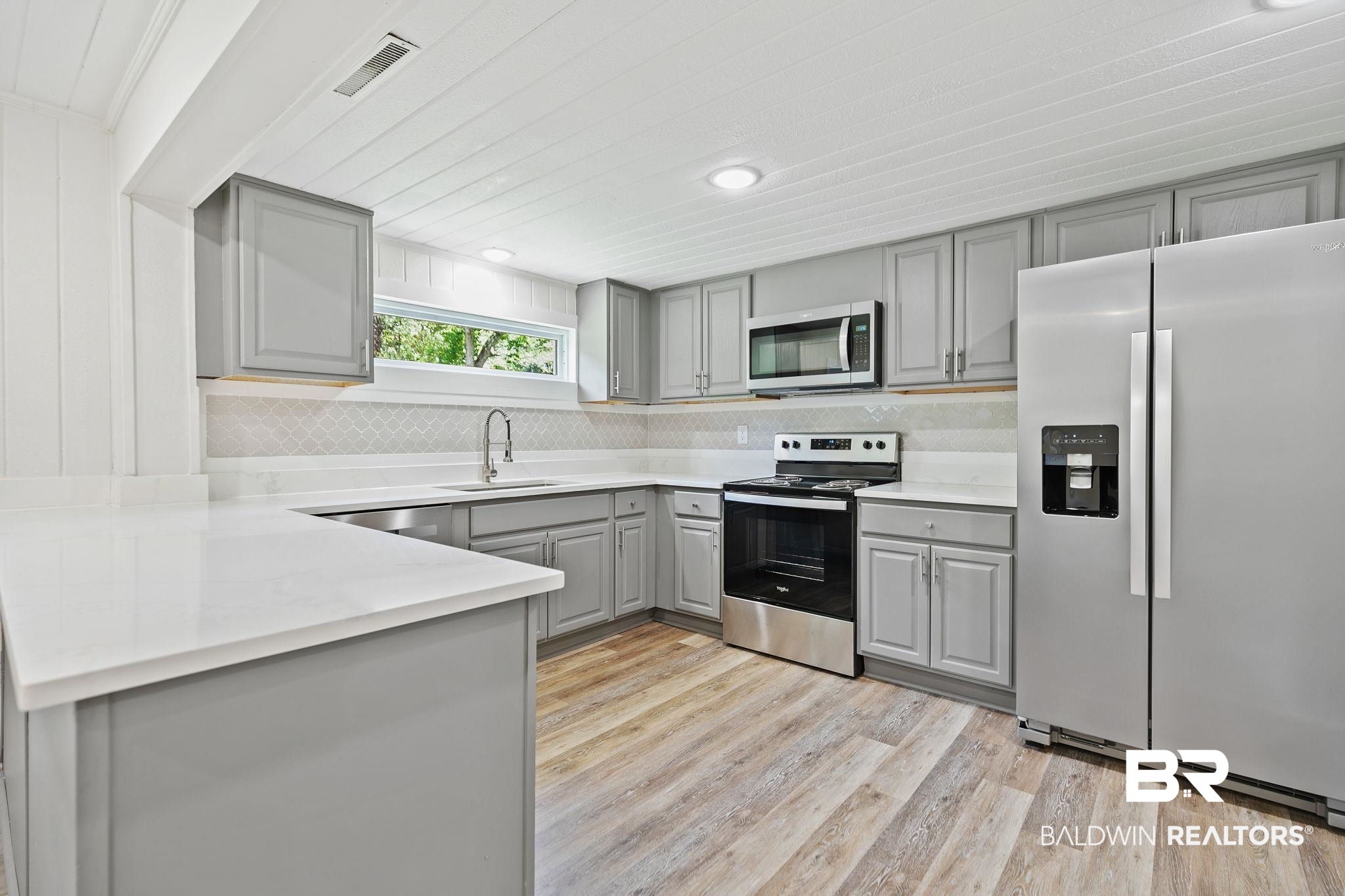 507 Byrne Street Bay Minette, AL 36507 - Photo 9 of 40 Kitchen featuring sink, appliances with stainless steel finishes, light hardwood / wood-style flooring, and tasteful backsplash