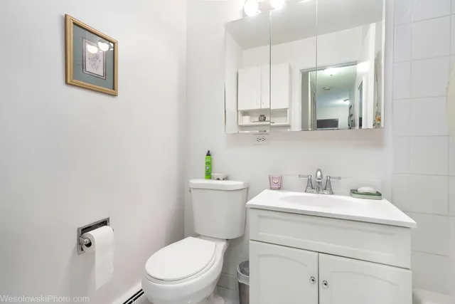 a bathroom with a toilet sink vanity and mirror