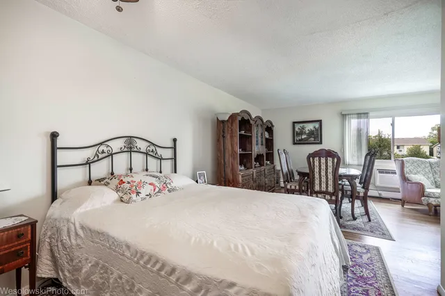 a bedroom with a bed a large mirror and a table