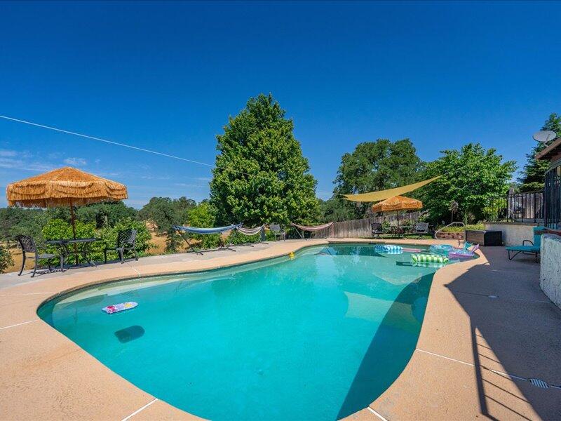 19907 Hidden Hills Road Cottonwood, CA 96022 - Photo 15 of 20 a view of a swimming pool with a yard and plants