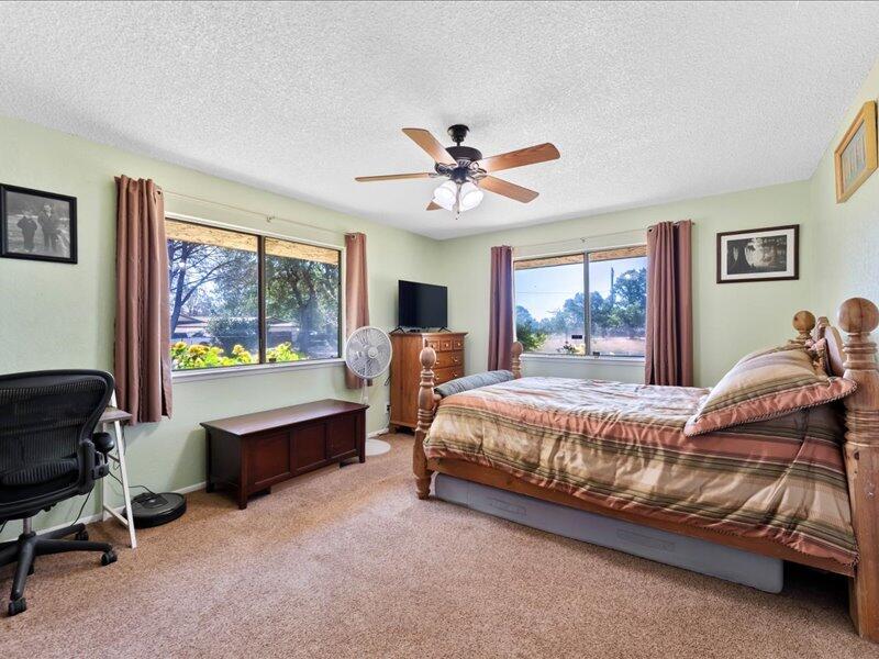 19907 Hidden Hills Road Cottonwood, CA 96022 - Photo 10 of 20 a bedroom with a bed and a chandelier