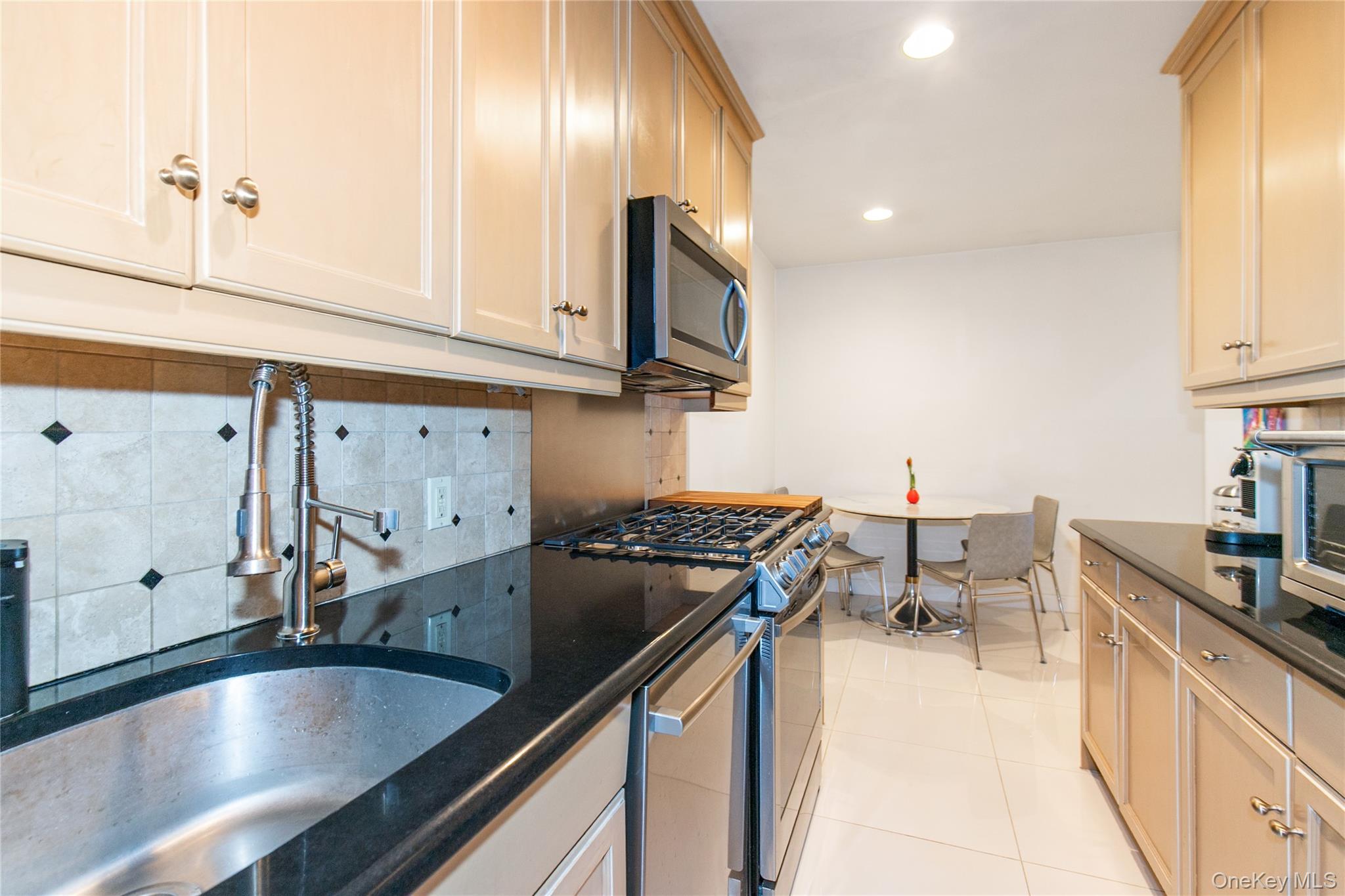 90 Schenck Avenue, Unit 3P Great Neck, NY 11021 - Photo 12 of 24 a kitchen with granite countertop a sink stainless steel appliances and cabinets