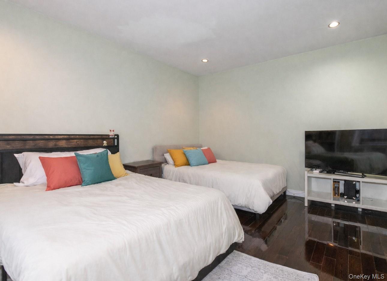 90 Schenck Avenue, Unit 3P Great Neck, NY 11021 - Photo 18 of 24 a bedroom with a bed and a flat screen tv