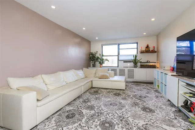 a living room with furniture a flat screen tv and a floor to ceiling window