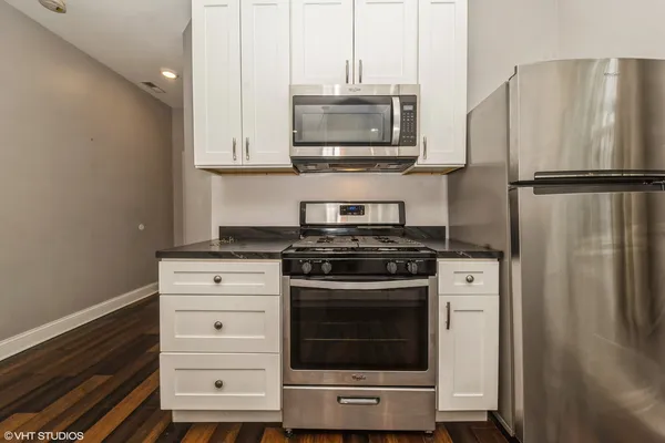a kitchen with stainless steel appliances a stove a microwave and a refrigerator