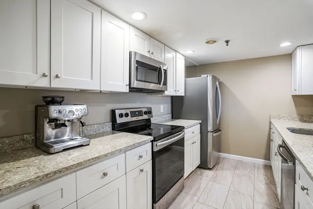 a kitchen with stainless steel appliances granite countertop a refrigerator sink and stove