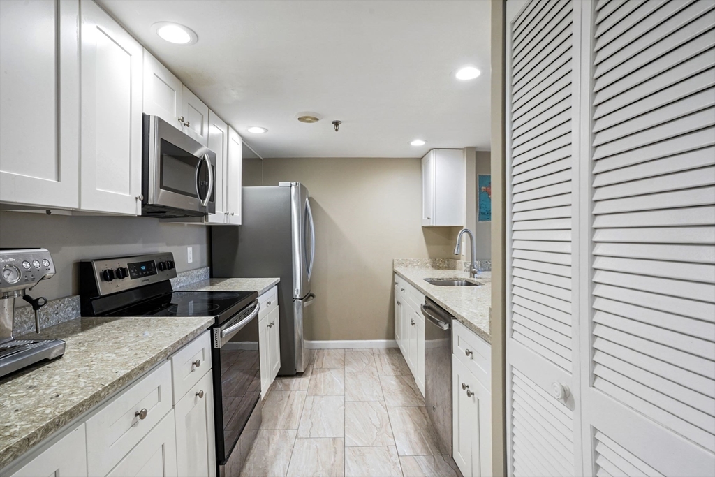 20 Webster Street, Unit 605 Brookline, MA 02446 - Photo 16 of 40 a kitchen with stainless steel appliances granite countertop a sink stove and refrigerator