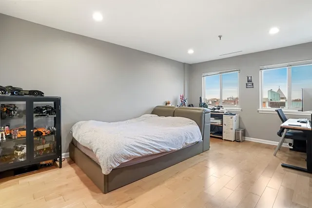 a spacious bedroom with a bed and a view of kitchen