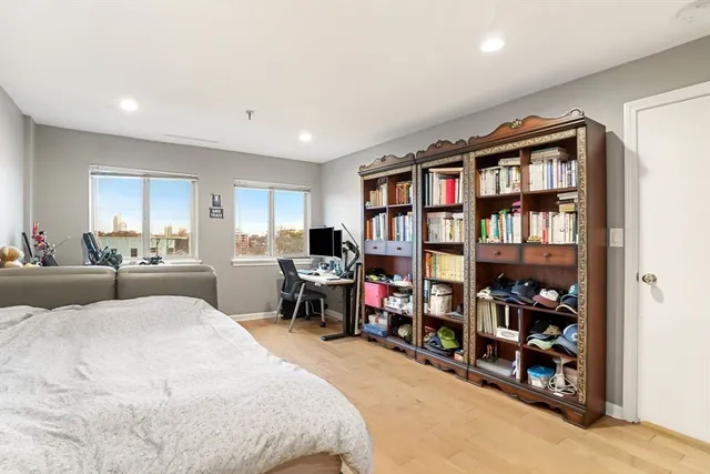 a bed room with a bed a book shelf and a window
