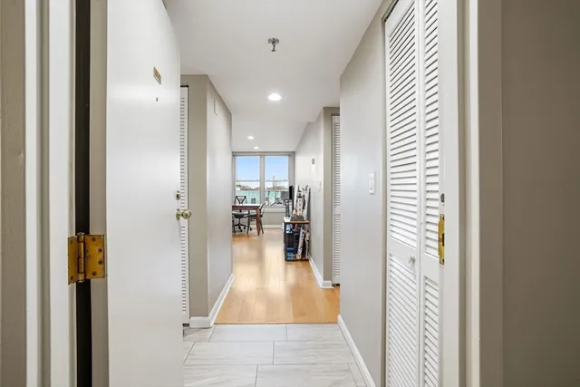 a view of a hallway with dining table and chairs