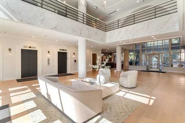 a view of a dining hall with a dining table chairs and couches with chandelier