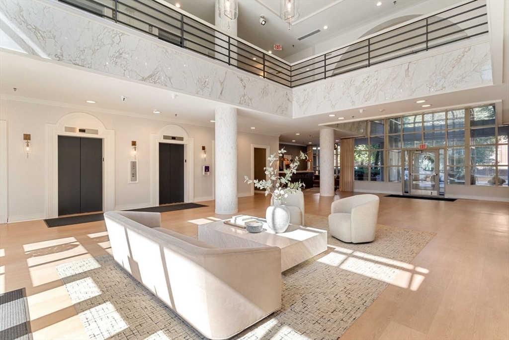 20 Webster Street, Unit 605 Brookline, MA 02446 - Photo 32 of 40 a view of a dining hall with a dining table chairs and couches with chandelier