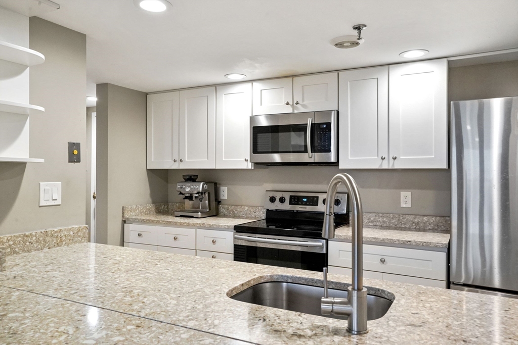 20 Webster Street, Unit 605 Brookline, MA 02446 - Photo 10 of 40 a kitchen with granite countertop a stove a sink and a refrigerator