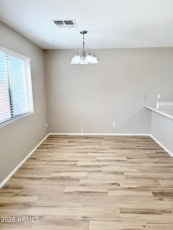 a view of a room with wooden floor and chandelier