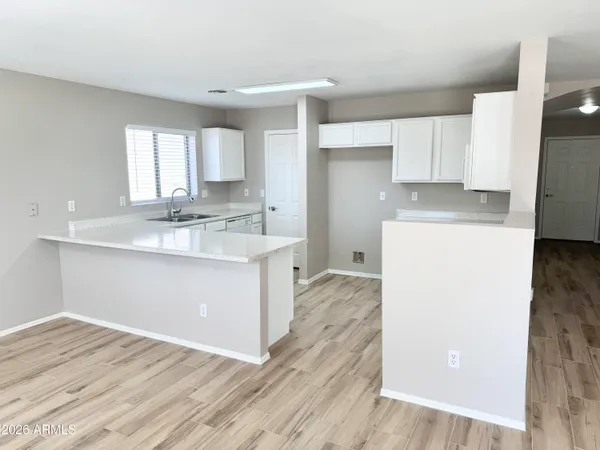 a kitchen with a sink a stove cabinets and wooden floor