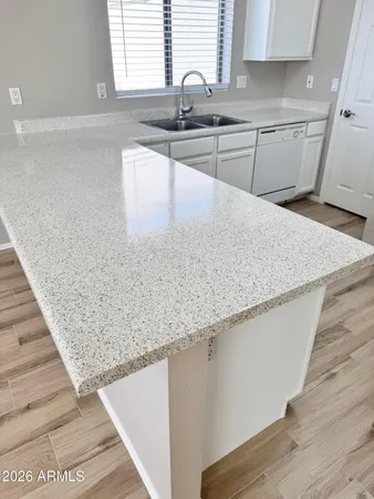 a kitchen with granite countertop sink and cabinets