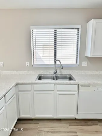 a kitchen with stainless steel appliances granite countertop a sink and a white wooden cabinets