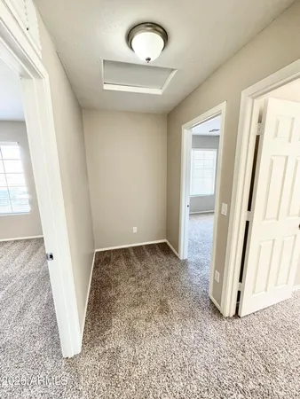 an empty room with windows and chandelier fan