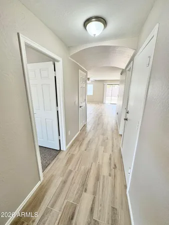 a view of a hallway with wooden floor and staircase