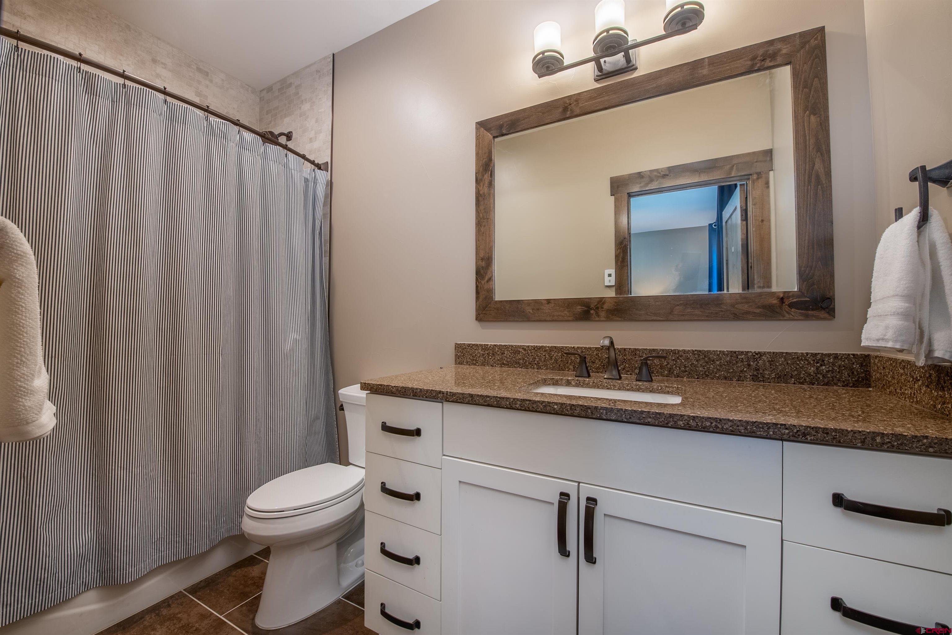 14 Ace Court Crested Butte, CO 81224 - Photo 13 of 24 a bathroom with a granite countertop sink vanity mirror and toilet