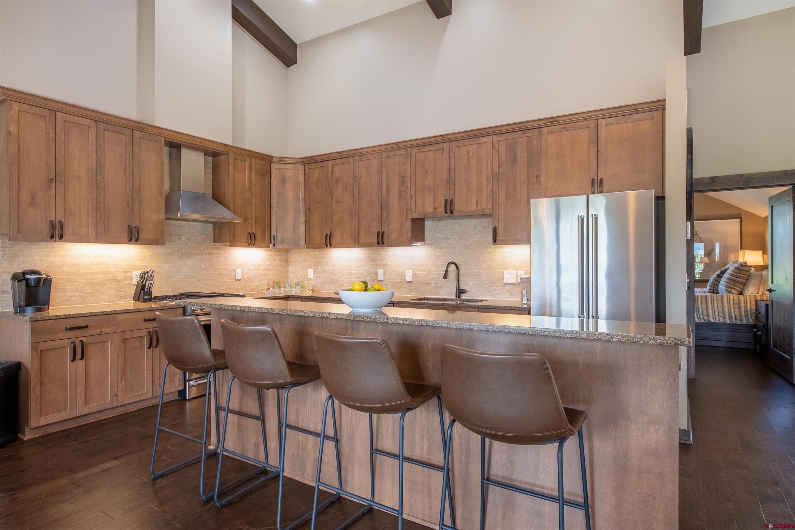 14 Ace Court Crested Butte, CO 81224 - Photo 7 of 24 a kitchen with stainless steel appliances granite countertop a table chairs sink refrigerator and cabinets