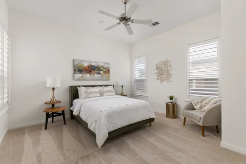 a spacious bedroom with a bed a couch and a chandelier