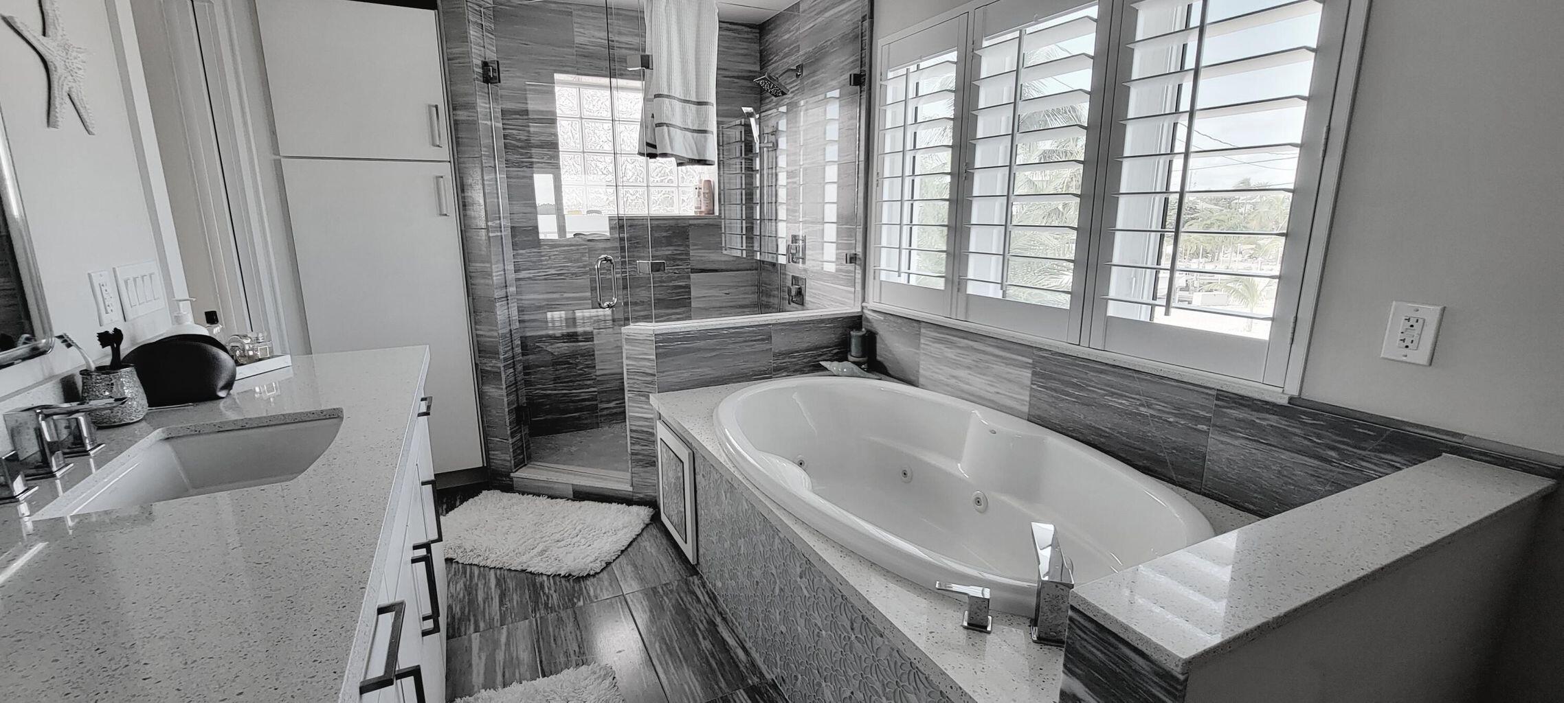 101 Windy Point Circle Marathon, FL 33050 - Photo 51 of 66 a bathroom with a granite countertop tub a sink and a large window
