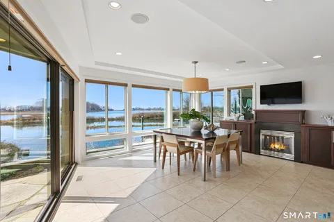 a dining room with furniture and a floor to ceiling window