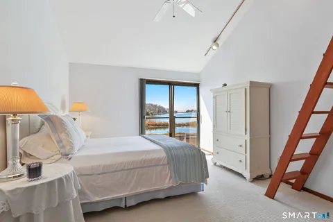 a bedroom with a bed and large windows