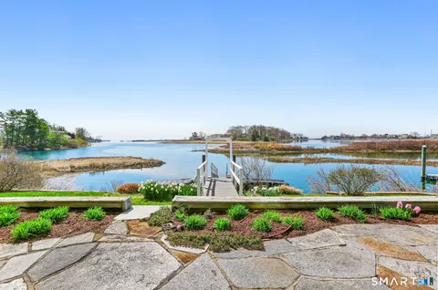 a view of a lake with a lawn chairs and a table