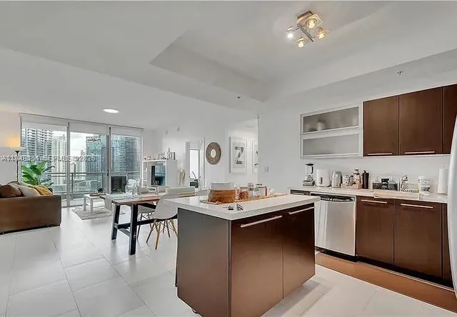 a kitchen with a stove a sink a dining table and chairs